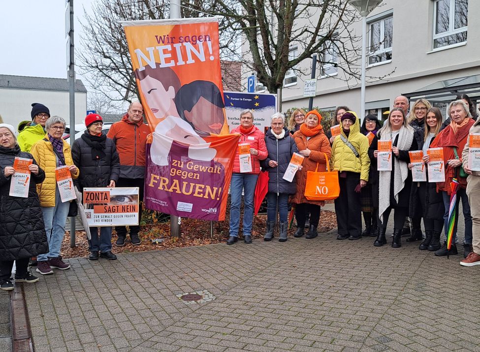 Zu sehen ist ein Gruppenfoto mit den Beteiligten bei der Fahnenhissung anlässlich des Internationalen Tages gegen Gewalt an Frauen und Mädchen